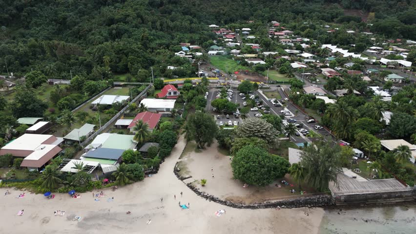 Seacoast Town With White Sand At Plage Vaiava Beach In Puna'auia, French Polynesia. Aerial Pullback Shot