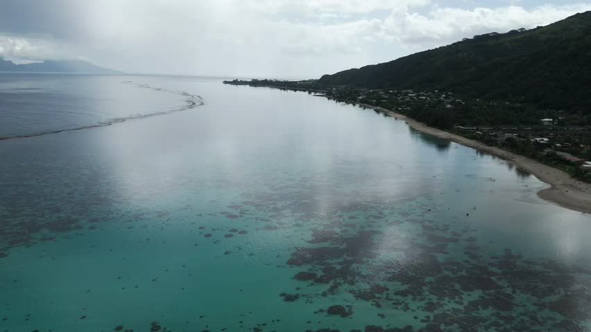 Tranquil And Clear Water Of Plage Vaiava Beach In Puna'auia, Tahiti, French Polynesia. - aerial shot
