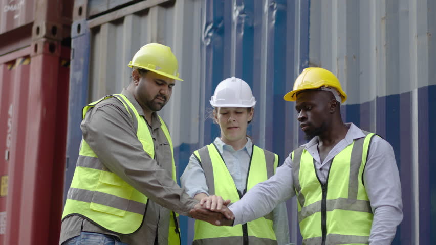 Group of many nationalities professional dock worker and engineering people stand with their hands together in container terminal, Business Cargo and Logistic, Success teamwork, Motivational