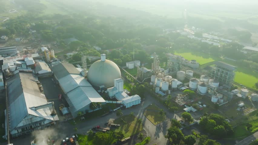 A modern sugar processing and alcohol aging plant, showcasing its impressive infrastructure and vast scale. The aerial perspective reveals the intricate layout of the facility, with processing units.