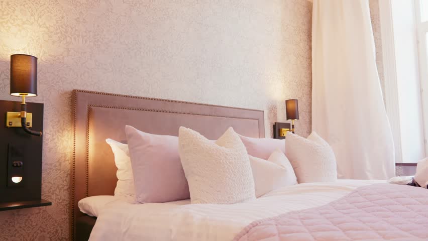 Close up of decorative pillows arranged neatly on a plush hotel bed highlighting soft textures and cozy design warm ambient lighting enhancing inviting atmosphere luxurious comfort attention detail