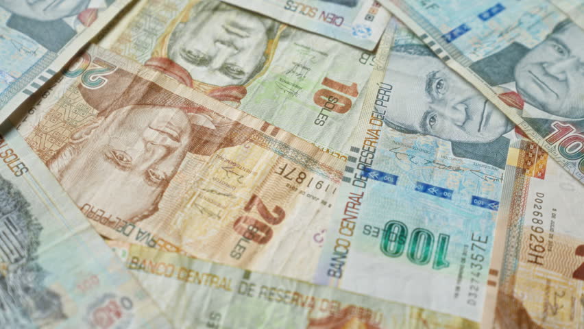 Scattered peruvian banknotes in various denominations featuring notable historical figures and vibrant designs, highlighting the diversity and richness of peru's currency.