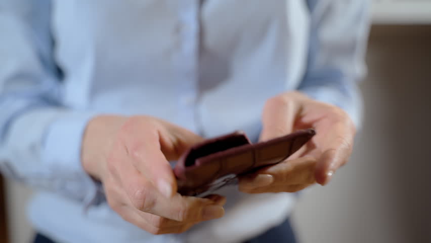 Woman opens red wallet and it is empty