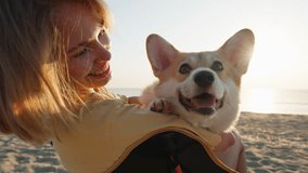 Portrait girl hugs corgi dog pet with tendernesssit on sandy beach, sharing peaceful moment at sunrise by ocean summer. Serene coastal setting warm light highlight companionship relaxation in nature.  - Powered by Shutterstock - Get 15% off with code: PIKWIZARD15