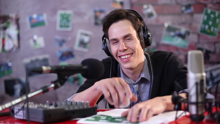 Young man smile. Smiling radio DJ or TV show presenter on the air in studio