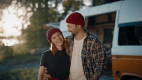 Couple of happy travelers in camp in forest motorhome trip in summer vacation. Family exploring wilderness by camper van, cheerful man and woman embracing, smiling and looking at camera, happy people - Powered by Shutterstock - Get 15% off with code: PIKWIZARD15