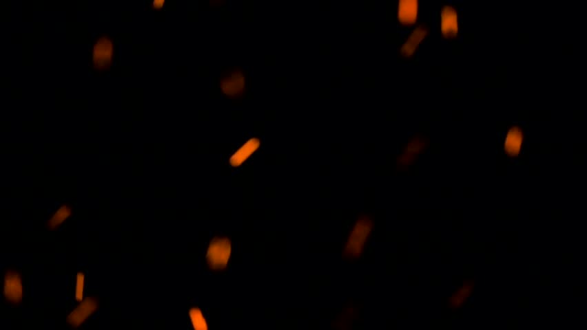 Glowing orange embers floating gently on dark black background