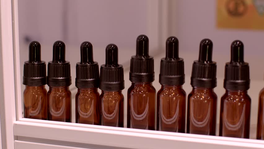 Closeup Collection of amber dropper bottles is artfully lined up, making them ideal for storing essential oils, serums, or herbal extracts. Highly professional storage solution. Close-up bottles
