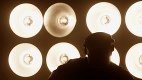 Silhouette of a dj wearing headphones, dancing energetically on stage, surrounded by pulsating lights that create an electrifying atmosphere for the crowd - Powered by Shutterstock - Get 15% off with code: PIKWIZARD15