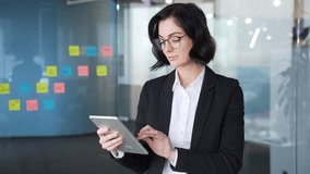 Confident businesswoman using tablet at workplace in office. Professional female employee concentrating on digital device to accomplish tasks. Modern business concept with technology and organization - Powered by Shutterstock - Get 15% off with code: PIKWIZARD15