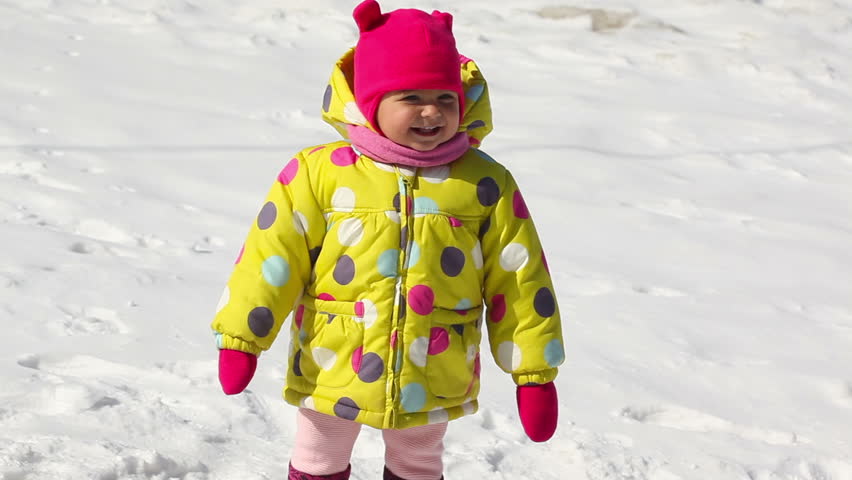Happy small girl clapping at winter time outdoor