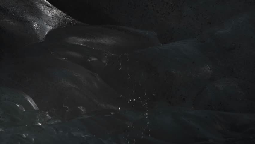 Explore the subtle beauty of an Icelandic ice cave where gentle streams of water trickle down the blue-hued ice walls.