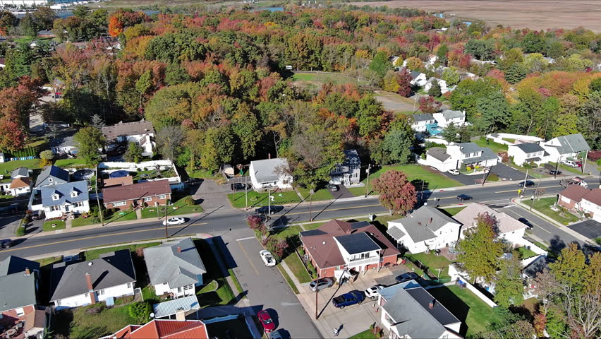 Aerial view showcases vibrant fall foliage over homes park in American suburban setting on South River town New Jersey USA