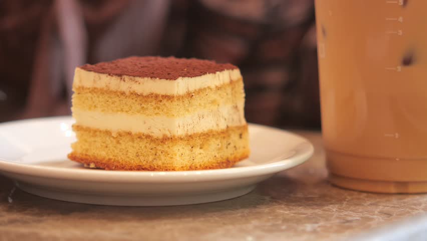 A scrumptious layered cake paired with a delightful coffee beverage beautifully placed on the table