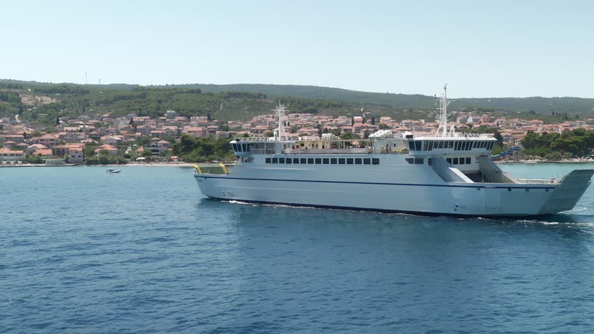 A ferry transports cars and passengers across the Adriatic Sea between the port city of Split and the island of Brac. Transportation and maritime connection between mainland Croatia and the islands.