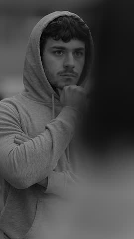 A Mysterious Figure Dressed in a Hoodie Surrounded by an Artistic Blur of Colors and Shapes