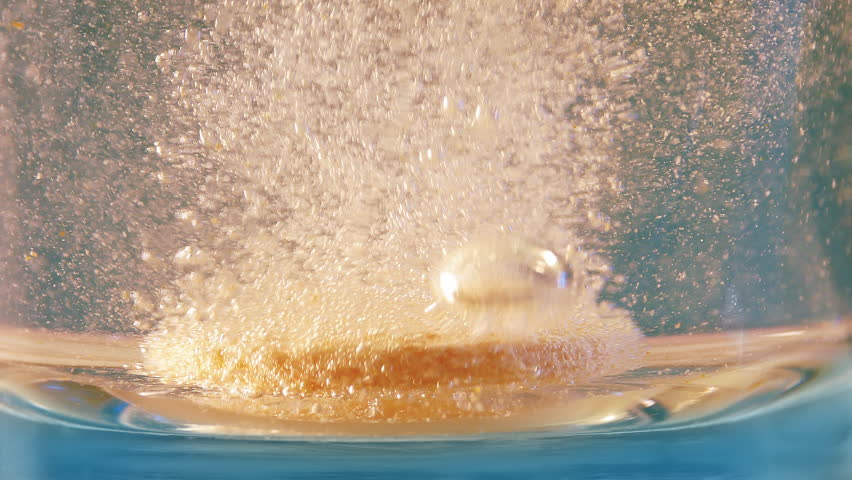 Vitamin Tablet Drops Into Glass Of Water And Fizzes