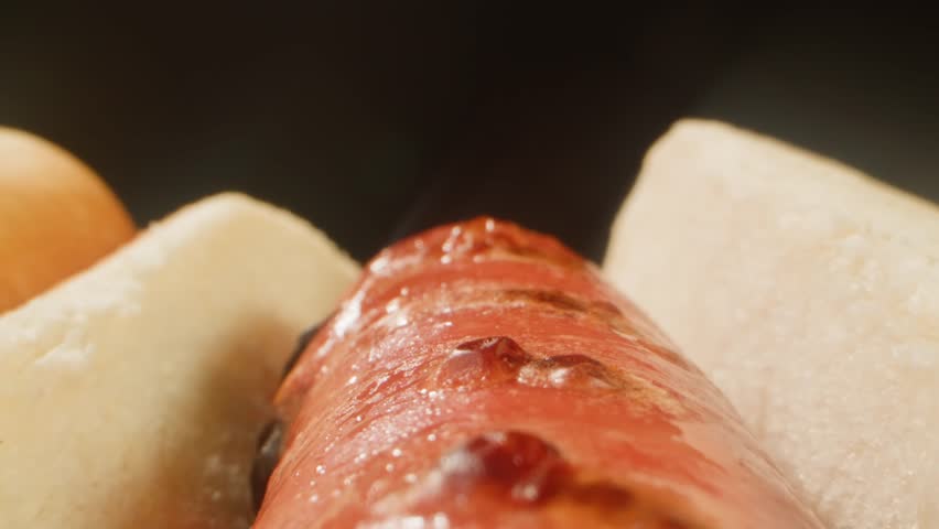 Ketchup tomato sauce Pouring on a Hot Dog with Sausage, close up of cooking hot dog in cafe restaurant.