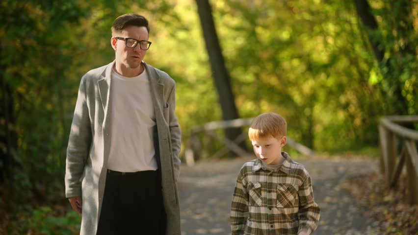 A father and son stroll through a colorful park, savoring a meaningful moment and enjoying the beauty around them