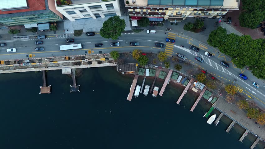Lakeside road, boats, and buildings in lugano, switzerland on a clear day, aerial view