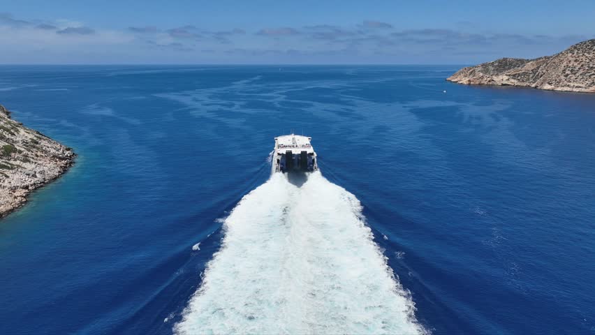 Aerial drone cinematic video of high speed passenger vessel departing from port of Sifnos island, Cyclades, Greece