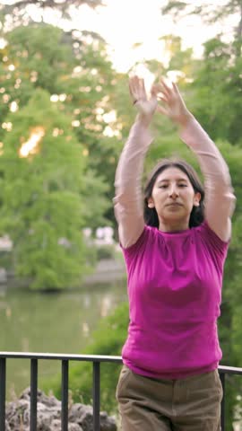 Young peruvian latin woman dancing by lake in slow motion