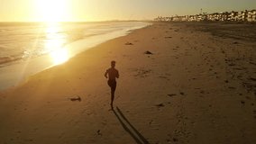 Aerial shot of a Athletic African American Man jogging on the beach at sunset - Powered by Shutterstock - Get 15% off with code: PIKWIZARD15