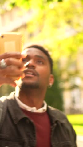 African man visiting a city taking photos with a mobile phone during sunset