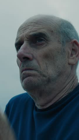 Cold And Sad Elderly Bald Man Rubs His Hands To Warm Up Outdoors