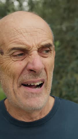 Elderly Bald Man Makes a Gross Face After Eating Bad Food In Nature