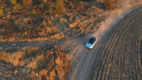 Aerial view of electrical car speeding through dusty route. Ecology friendly auto on electric charge driving along rural road. Concept of freedom or modern technologies. - Powered by Shutterstock - Get 15% off with code: PIKWIZARD15