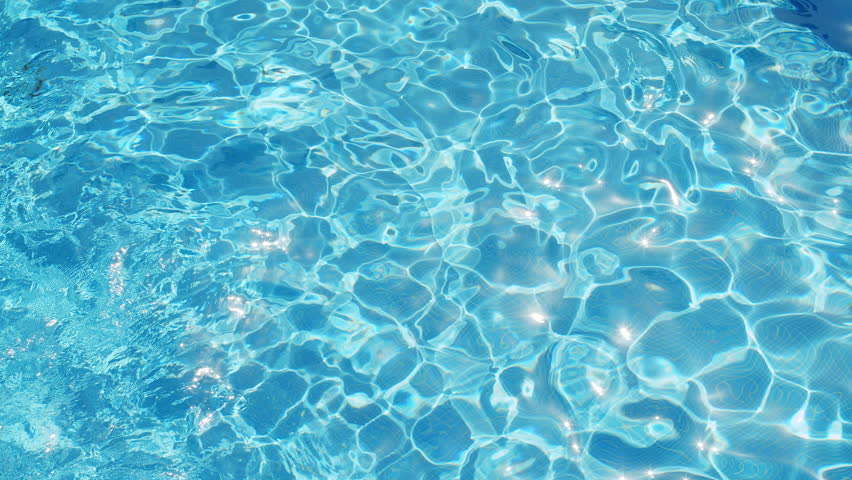 Ripples on the water of the pool, transparent, sparkling, inviting surface of the water in motion, view from above. slow motion and looped video.