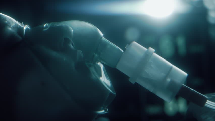 Female patient on life support with oxygen mask in hospital intensive care unit. Emergency treatment and monitoring in ICU with vital signs on screen, healthcare, medical care, and recovery treatment