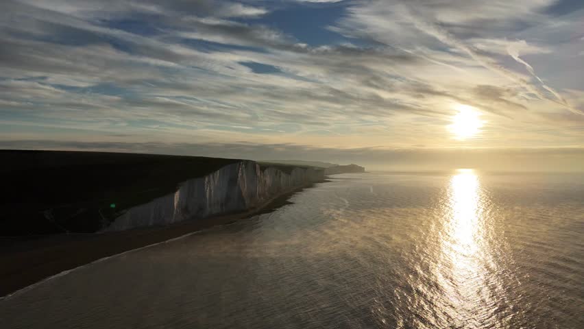 An aerial footage of the Cuckmere Haven Beach and the Seven Sisters Cliffs at sunset in Seaford town in East Sussex, England, United Kingdom