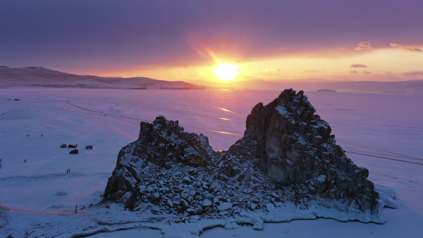 Aerial view of Shaman rock at sunset, one of sacred place in frozen lake Baikal in winter season of Siberia, Russia, 4k