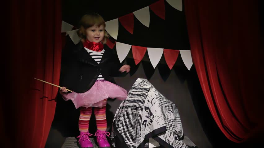 Small girl circus performer shows a trick with a hat and a rabbit in the spotlight. High quality 4k footage. High quality 4k footage