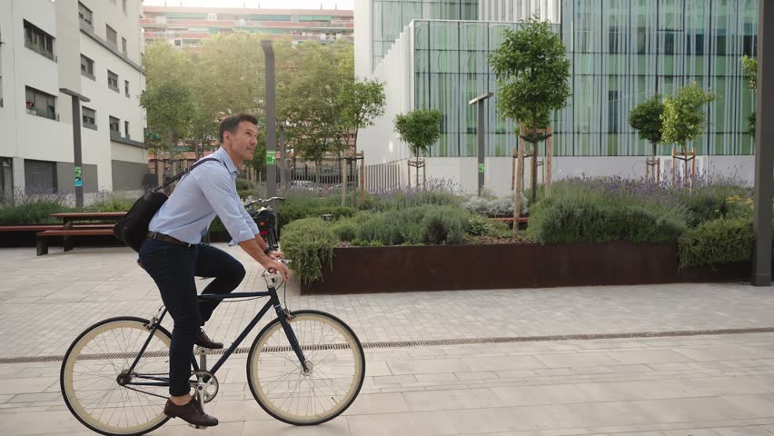 Elegant man going to work to the office by bicycle - Sustainable commuter transport the city 