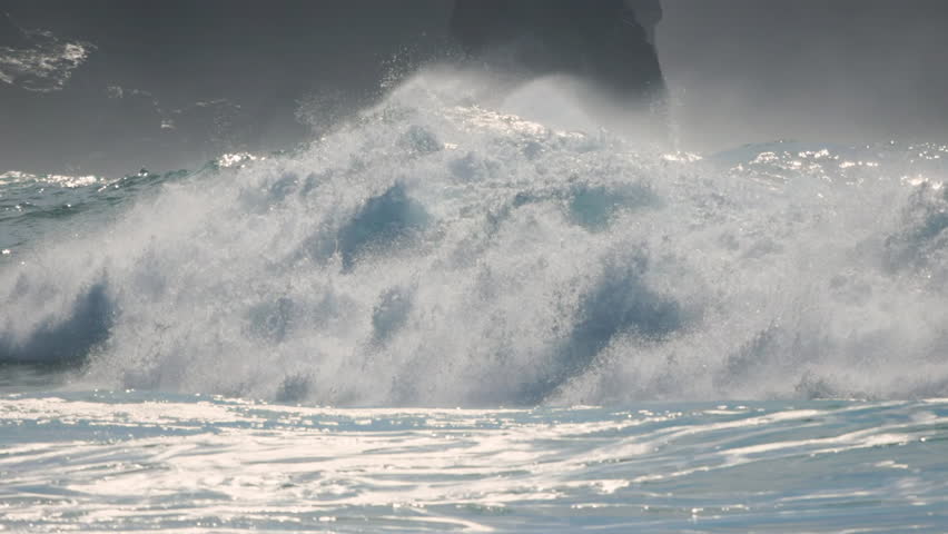 Waves crashing on a pristine beach in a coastal paradise during midday sunlight
