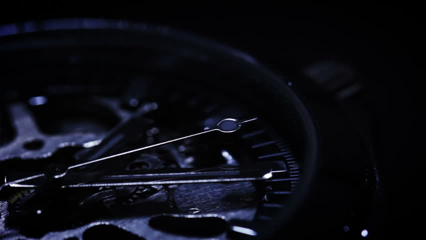 Black background. Mechanism of watch close-up. The moving beam of light