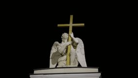 A detailed view of the angel statue holding a golden cross atop Saint Peter Church in Saint Petersburg. The white sculpture stands out against the dark night sky, symbolizing faith and hope while - Powered by Shutterstock - Get 15% off with code: PIKWIZARD15