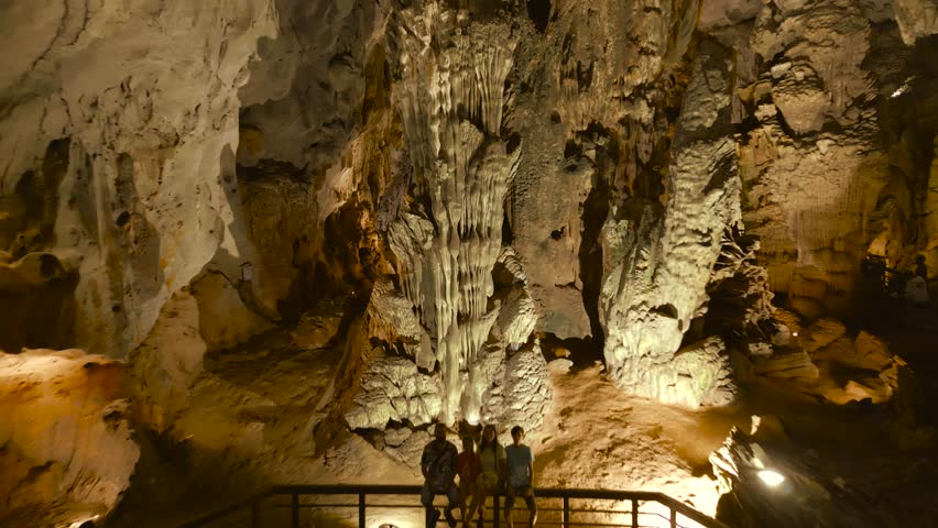 A family enjoys the stunning formations inside Phong Nha Cave, showcasing the natural beauty of Son Doong's impressive limestone structures.