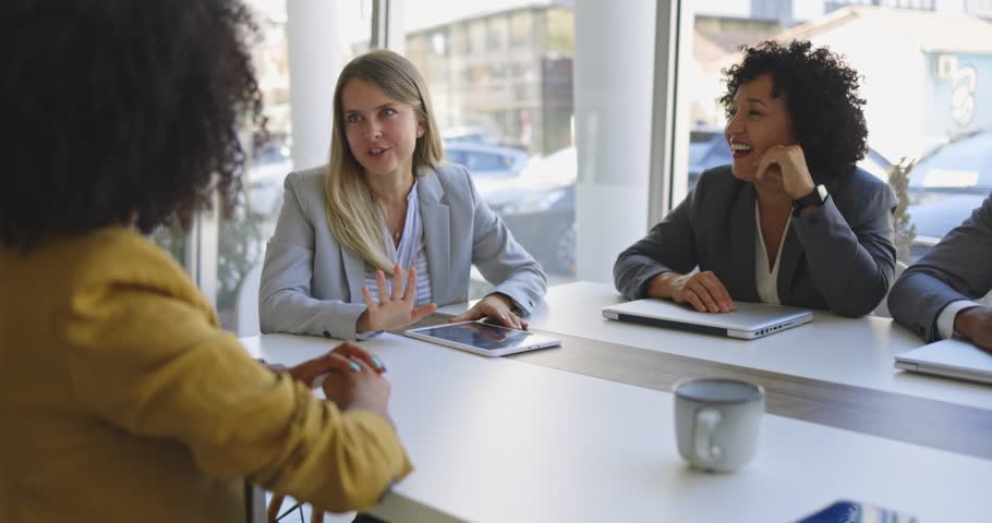 Happy diverse colleagues laugh together during a business meeting in the office. They work together and discuss ideas. Teamwork and success.