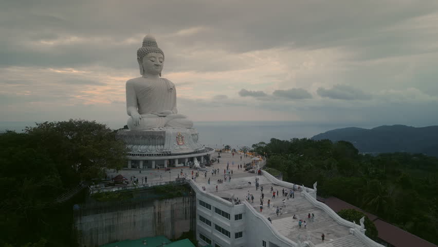 Big Buddha monument surrounded by crowd of curious tourists in Thailand aerial view. Spiritual place of Phuket offers calmness and panoramic views of beaches and landscapes at sunrise