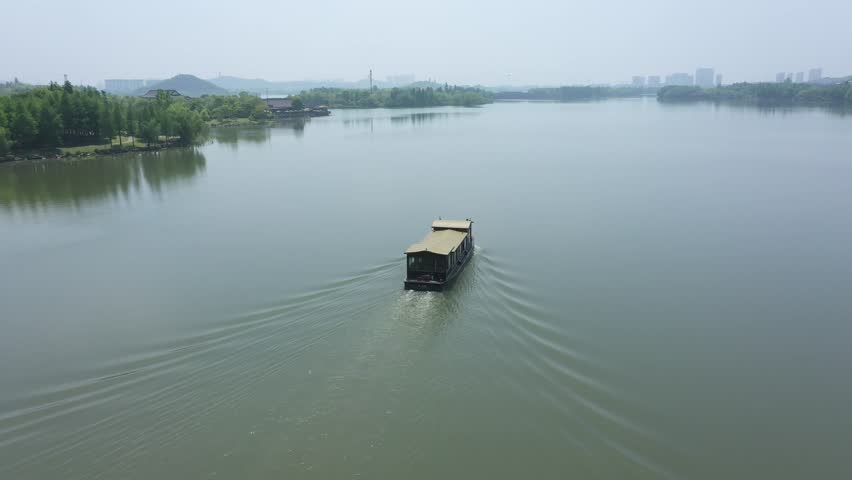 A drone shot of a tourist boat sailing in the xianghu lake in day time in Hangzhou, China