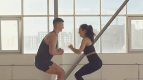 Athletic couple Generation Z in sportswear young woman and man at workout together jumping on the wooden box in sunlight in fitness sport gym, Side View 4K UHD B-Roll footage - Powered by Shutterstock - Get 15% off with code: PIKWIZARD15