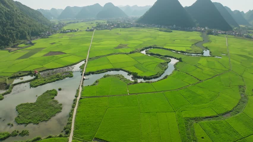 Drone aerial view of landscape green rice field mountains view with clouds flowing over mountains,High angle view sunset colorful clouds over countryside at northern Vietnam