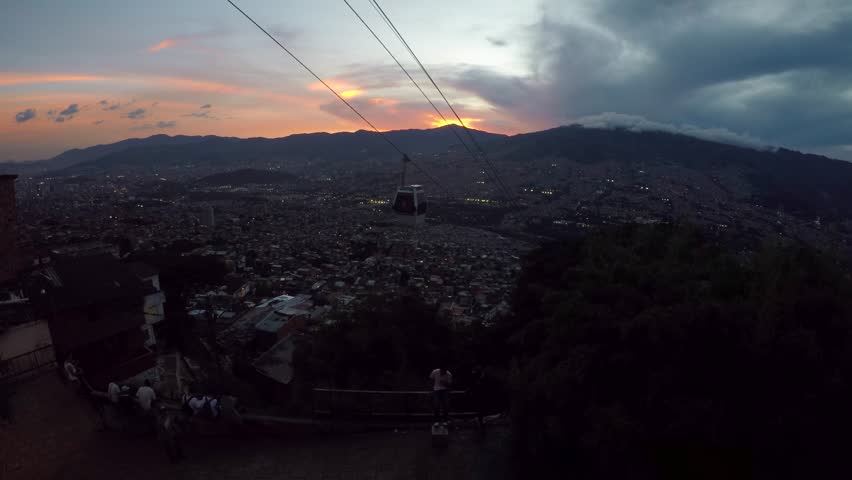 A wide view of gondolas going over the favelas during sunset in the city of Medellin, Colombia