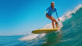Young athletic woman in a blue swimsuit is riding a yellow surfboard on ocean waves. Maldives - Powered by Shutterstock - Get 15% off with code: PIKWIZARD15