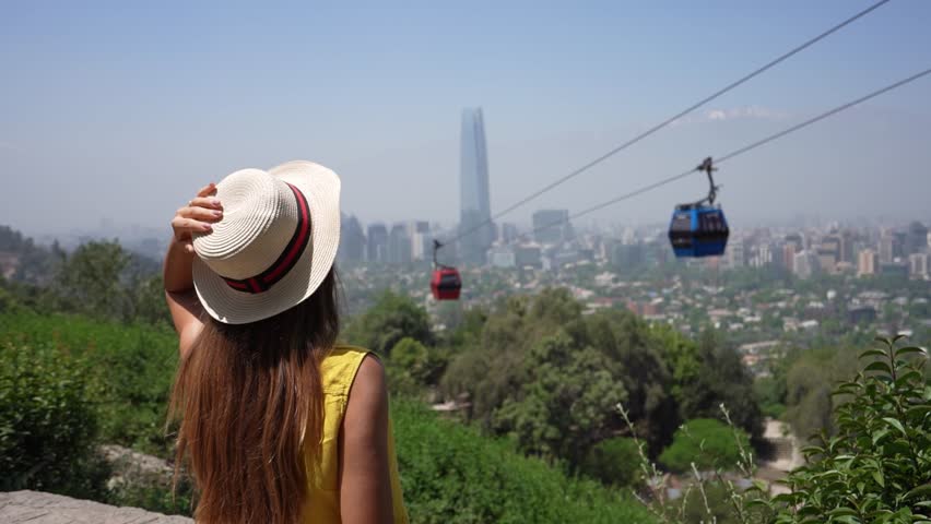 Tourism in Santiago de Chile. Rear view of traveler girl looking at cable cars in Santiago Metropolitan Park, Chile, South America.