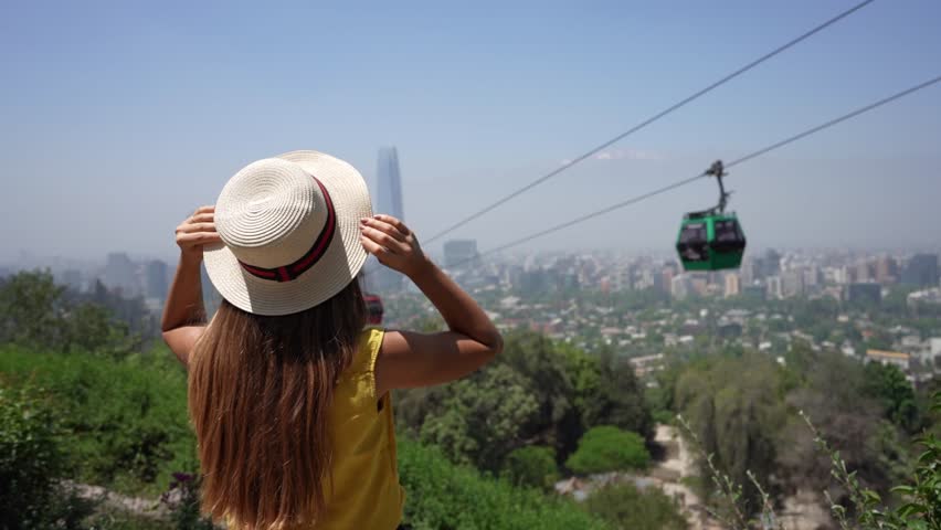 Holidays in Santiago de Chile. Back view of beautiful girl enjoying view of cable cars in Santiago Metropolitan Park, Chile. Summer vacation in South America.
